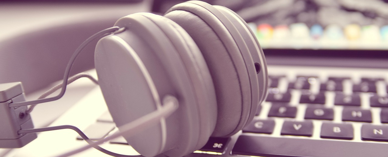 Headphones on the keyboard on a laptop, depicting a typical way to flee loud environments